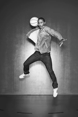 Black man jumping in mid-air holding a basketball in a studio shot photographed by Ben Watts