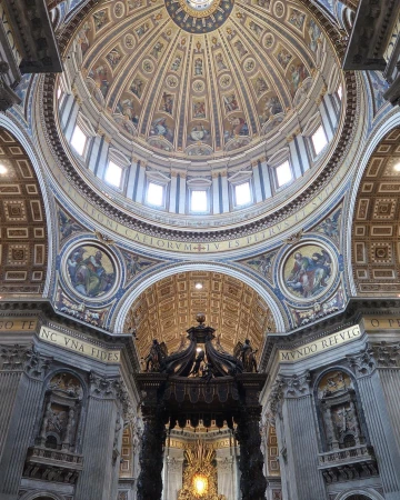 Intricate architecture of St. Peter's Basilica dome features paintings, windows, and ornate carvings, creating a visually stunning interior view.