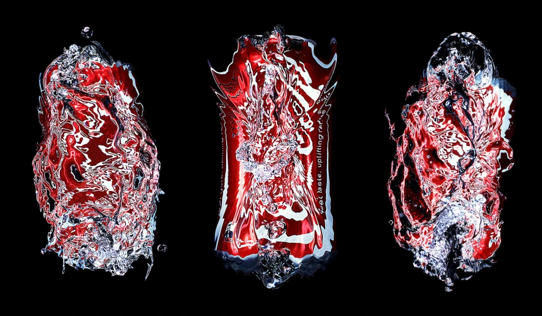 Three manipulated beverage cans with water droplets isolated against a black background creating an abstract and visually striking still life.