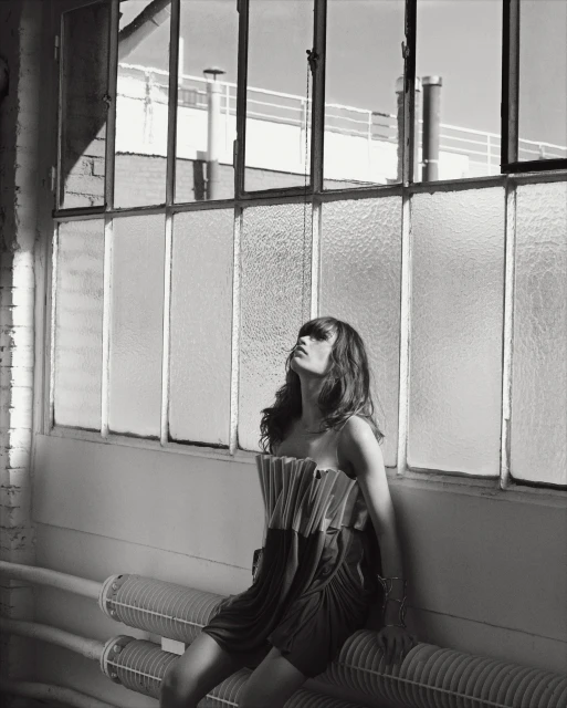 Adult woman poses in a red dress in a photo studio with a softbox light, black backdrop and neutral colors in a fashion style shoot.