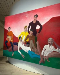 Large framed figurative painting depicting a group of people against a red background and green foreground displayed in a gallery