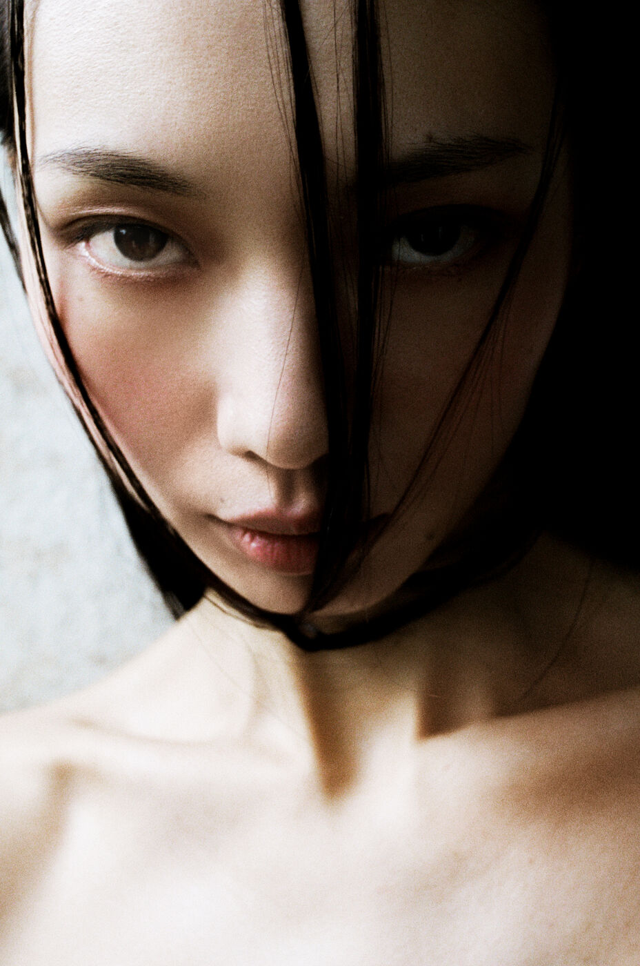 Close-up portrait of an East Asian woman with wet dark hair framing her face, captured by Jess Ruby James in Sydney.