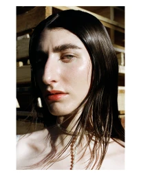 Portrait of a woman with dark hair and a gold choker necklace by photographer Jess Ruby James in Sydney.