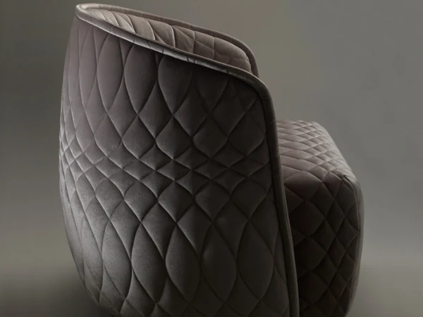 Close-up of a grey quilted armchair with a modern design. The quilted pattern is diamond-shaped, creating a plush, textured appearance.