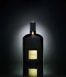 Black ribbed perfume bottle with gold label on dark background, photographed by Dieu Tan in Sydney