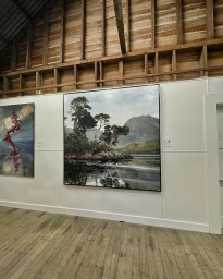 Large framed landscape painting of a lake and mountains mounted on a white gallery wall in Sydney.