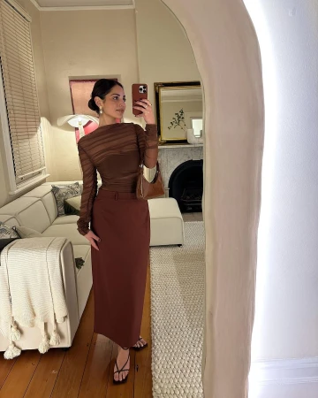 Content creator Jade Tunchy posing in a mirror wearing a brown long sleeve sheer top and midi skirt with a handbag in Sydney
