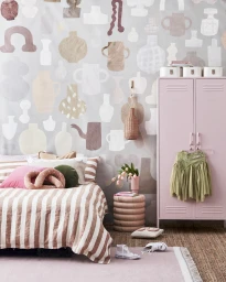 Pink bedroom interior styled by Jessica Hanson featuring vase-patterned wallpaper, pink locker, and striped bedding