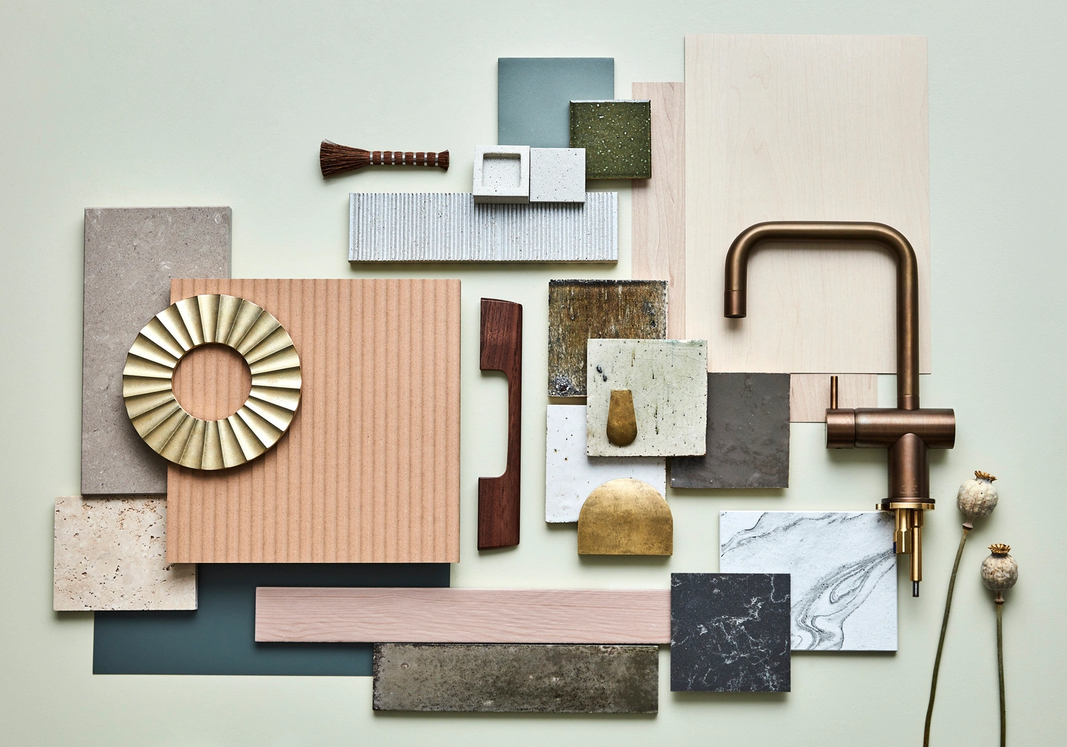 Flat lay material board featuring brass tapware, wood samples, stone tiles, and textured ceramic swatches by Jessica Hanson.