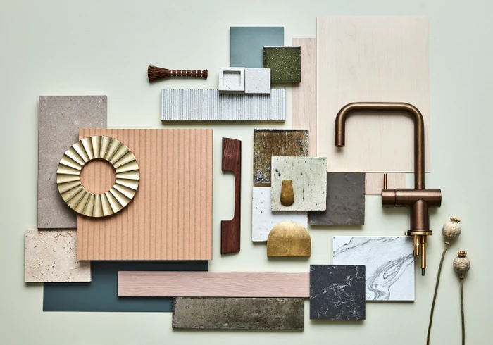 Flat lay material board featuring brass tapware, wood samples, stone tiles, and textured ceramic swatches by Jessica Hanson.