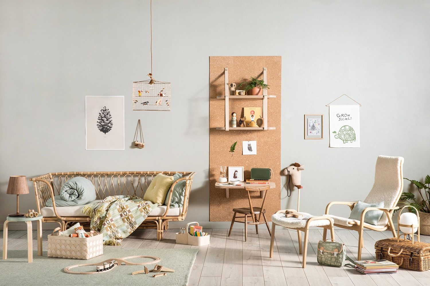 Childrens room interior styled by Jessica Hanson featuring rattan furniture, a cork wall panel, and wooden toys.