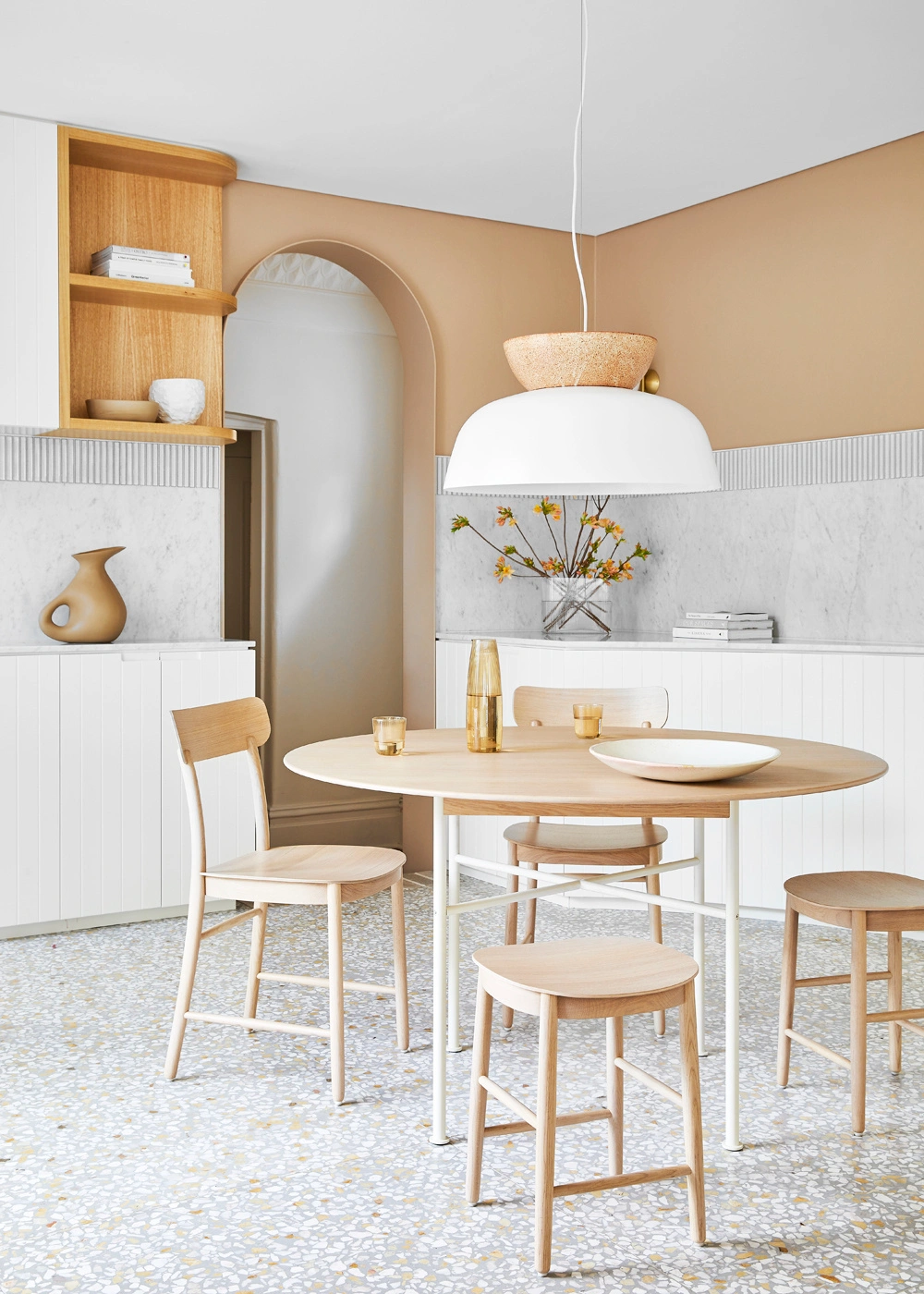Modern dining room with round light wood table, four chairs, stool, and pendant light styled by Jessica Hanson in Sydney.