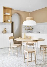 Modern dining room with round light wood table, four chairs, stool, and pendant light styled by Jessica Hanson in Sydney.