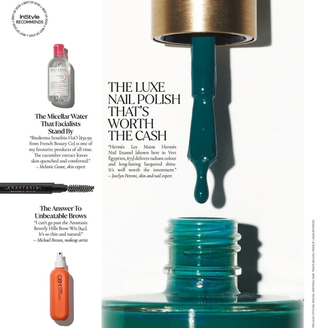 Close-up of nail polish dripping from a brush into an open bottle, surrounded by cosmetic product advertisements in a beauty magazine.
