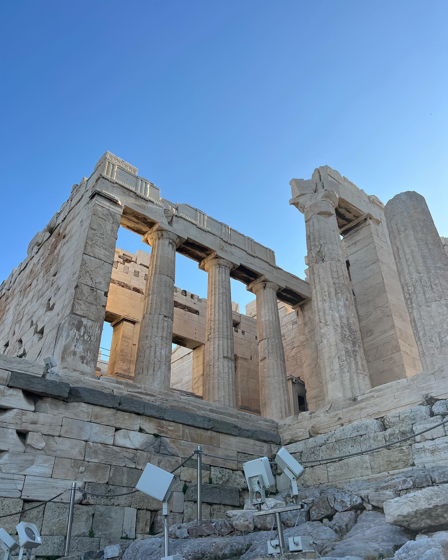 Scenic view of the Parthenon ruins in Athens, Greece under a clear blue sky. Ancient architectural details, stone and columns.