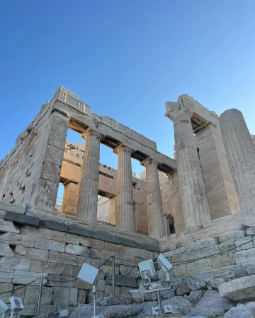Scenic view of the Parthenon ruins in Athens, Greece under a clear blue sky. Ancient architectural details, stone and columns.