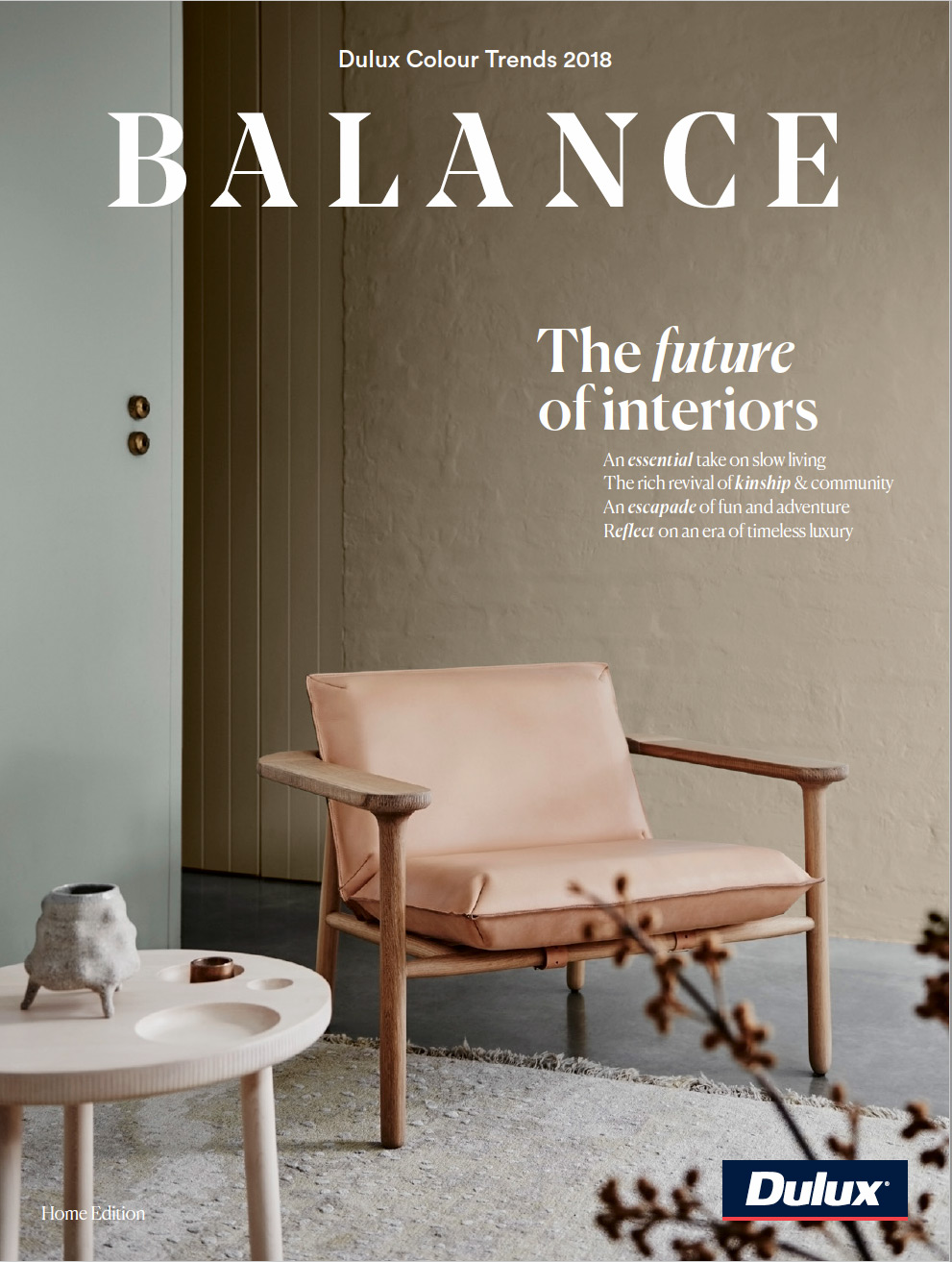 Interior design featuring a contemporary chair with a wooden frame, set on a patterned rug, complemented by a round side table.