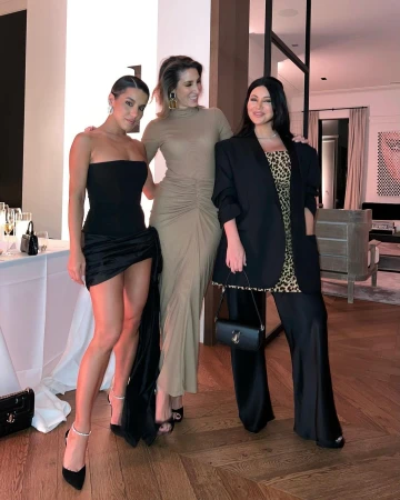 Three women posing together indoors wearing elegant evening attire in Sydney, captured by Martha Kalifatidis.