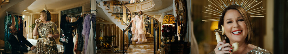 Woman in sequin dress and crown on a vintage phone smiles in a luxurious interior, with staircase and fashion rack in background.
