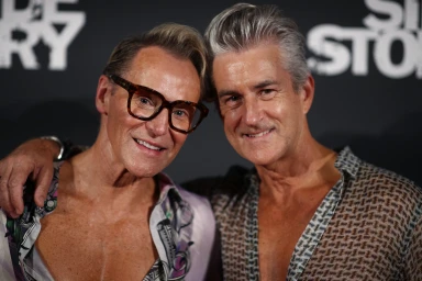 Two mature men posing together closely with patterned shirts against a dark backdrop in Sydney by Mitch and Mark