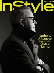 Profile portrait of a mature man in profile wearing dark coat and glasses against a dark background with magazine text overlay