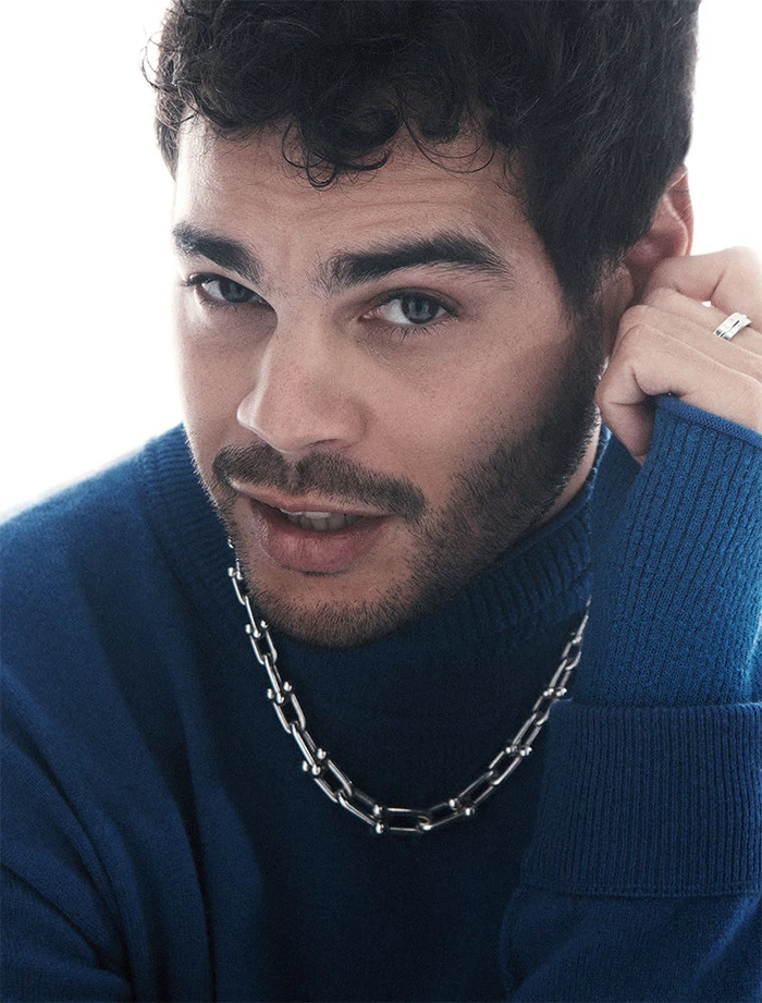 Close-up portrait of a man wearing a blue turtleneck sweater and a silver chain necklace in Sydney.