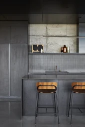 Modern dark wood kitchen interior with a central island and two wooden barstools by photographer Pablo Veigo