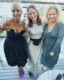 Three women posing on a balcony overlooking a marina with boats in Sydney by content creator Paula Joye.