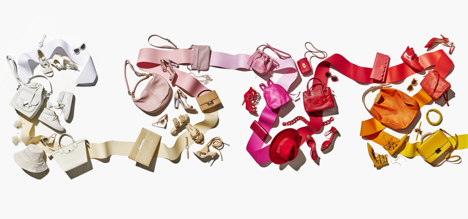 An array of colorful fashion accessories including handbags and shoes arranged by color, white to yellow, against a white background.