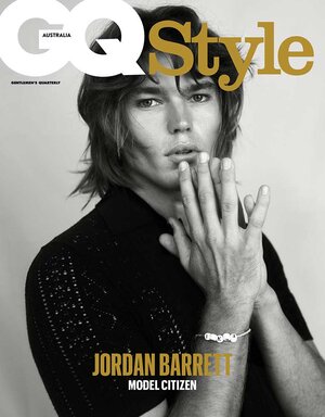 Magazine cover featuring adult male with hand gesture, black shirt, bracelet. GQ Style Australia text and logo visible. Neutral backdrop.