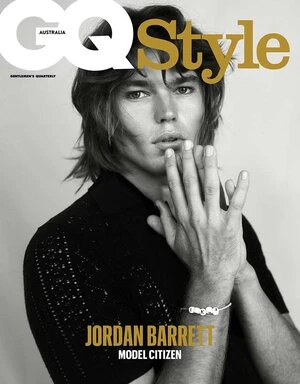 Magazine cover featuring adult male with hand gesture, black shirt, bracelet. GQ Style Australia text and logo visible. Neutral backdrop.
