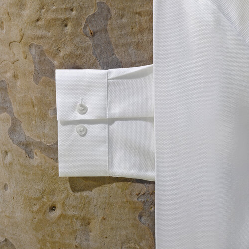 Close-up of a white dress shirt sleeve with cuff buttons, textured background adding depth and highlighting the crisp, clean fabric.