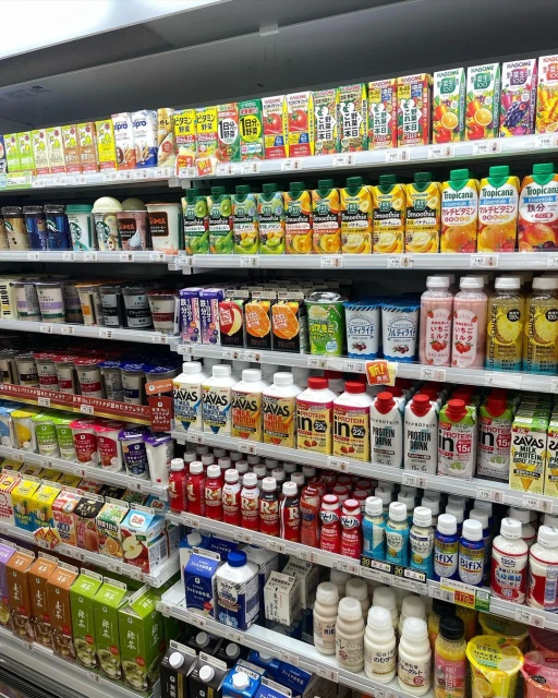 Grocery store shelf stocked with various juice and beverage products in bottles and cartons, showcasing a variety of drinks.