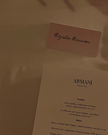 Table setting featuring a name card reading 'Rozalia Russian' and an Armani Beauty menu showcasing upcoming culinary offerings.