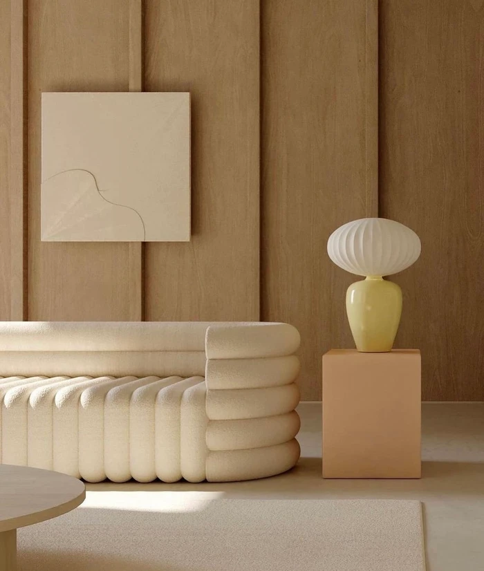 Modern textured cream sofa and yellow table lamp against vertical wood paneling wall in Sydney by Saasha Burns