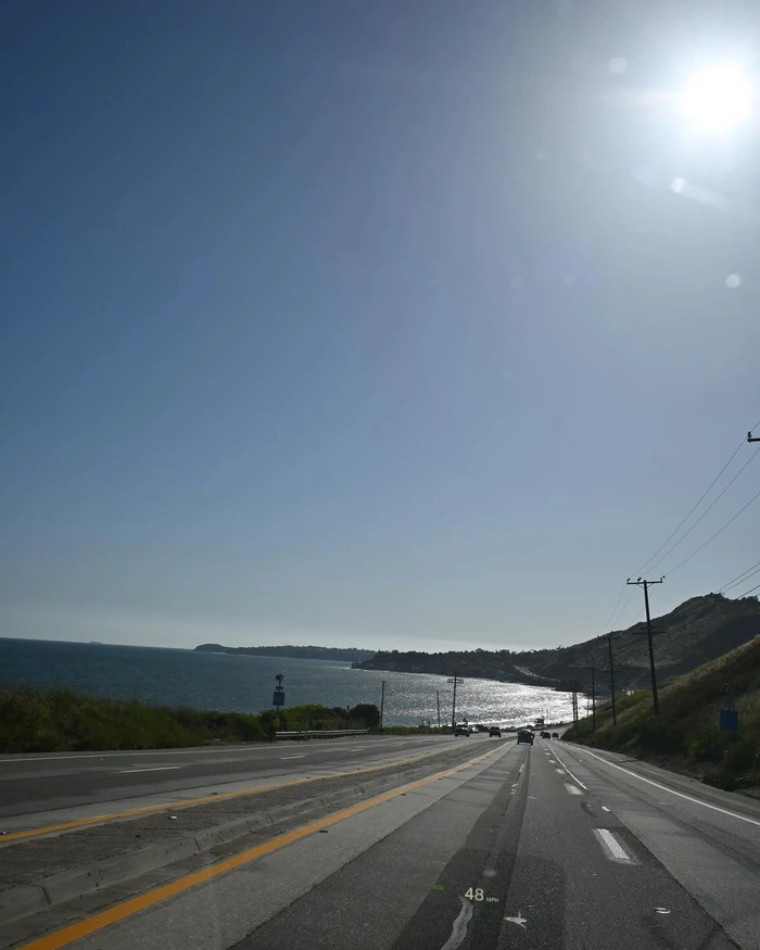 Coastal highway stretching down toward the ocean under a bright sunny sky, captured by Saskia Wotton in Sydney.