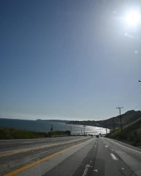 Coastal highway stretching down toward the ocean under a bright sunny sky, captured by Saskia Wotton in Sydney.