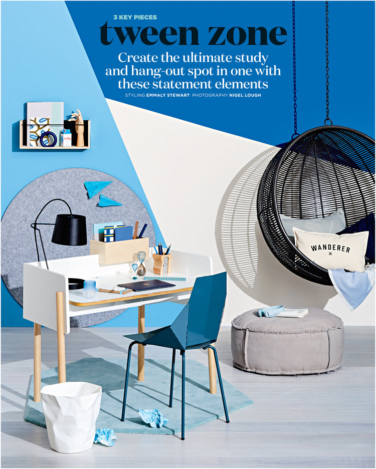 Modern study space featuring a white desk, blue chair, hanging wicker chair, and geometric decor in a room with blue and white walls.