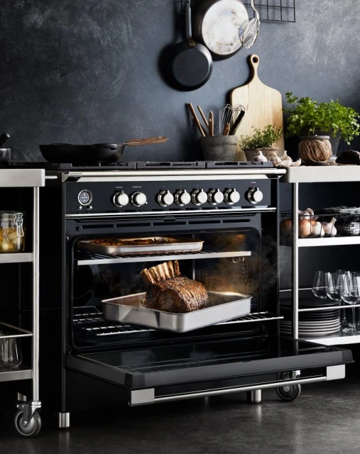 An oven with a roasting rack inside, showcasing a cooked roast, set in a kitchen with cooking utensils and tableware.