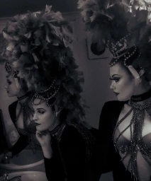 Performer in elaborate feather headdress and beaded collar posing in front of a mirror in Sydney by Tatiana Rose.