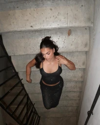 Woman in sparkly black two piece outfit descending concrete stairs shot from above in Sydney by Tuesday Granger.