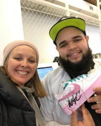 A woman and a bearded man holding a custom-painted sneaker in Melbourne, styled by Vanessa Timmins