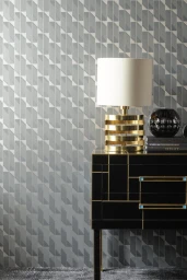 Black and gold cabinet styled with a metallic lamp and books against patterned wallpaper