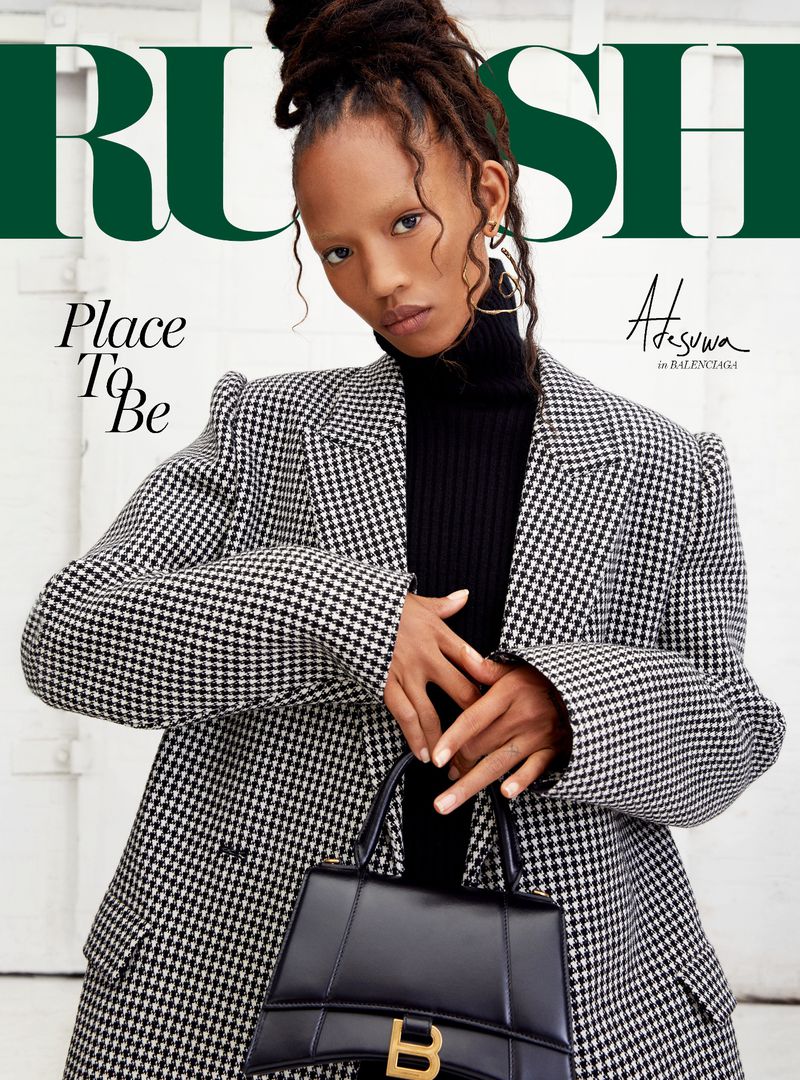 Magazine cover featuring a Black model in a houndstooth blazer and black turtleneck, holding a black Balenciaga purse. Dark green heading text.