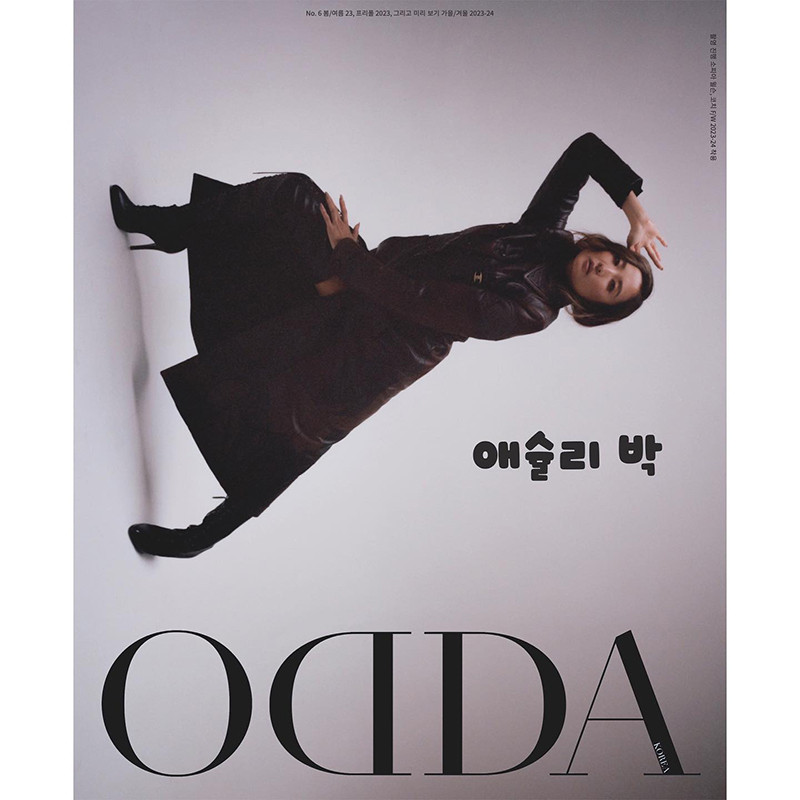 Editorial fashion shot of a woman in a leather coat posing against a grey backdrop, complemented by bold magazine text and sleek black boots.