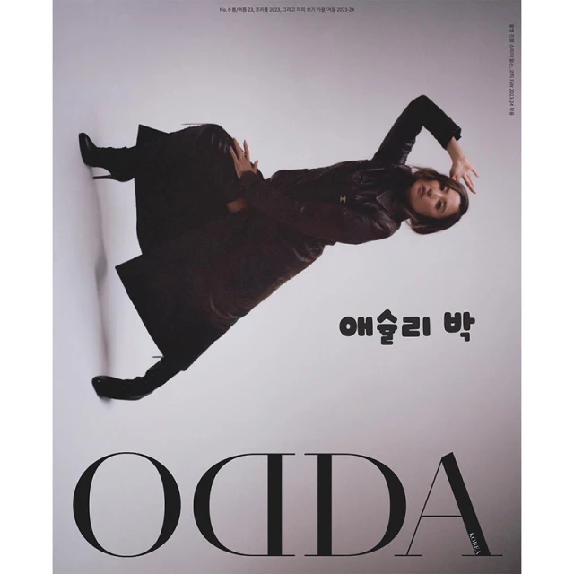 Editorial fashion shot of a woman in a leather coat posing against a grey backdrop, complemented by bold magazine text and sleek black boots.