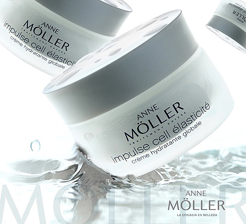 Close-up of Anne Möller Impulse Cell Élasticité creme jar with water droplets; beauty product, white container, skincare, cosmetics.
