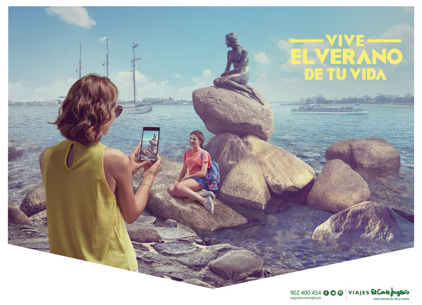 Woman taking photo with phone of woman posing near statue of The Little Mermaid by the sea with a sailing ship and blue sky.