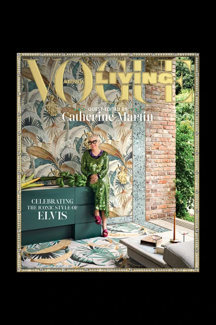 Vogue Living cover featuring Catherine Martin sitting on a teal bureau in a green sequin dress, surrounded by tropical-themed decor.