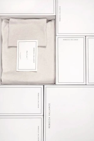 White boxes with product, neatly arranged. Clean product shot with visible brand label and complementary design card included.